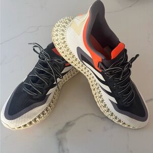 Adidas black and white sneakers with orange accents